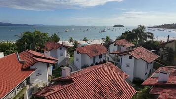 Un village côtier doté d’une architecture traditionnelle, d’une plage et de bateaux amarrés dans l’eau.
