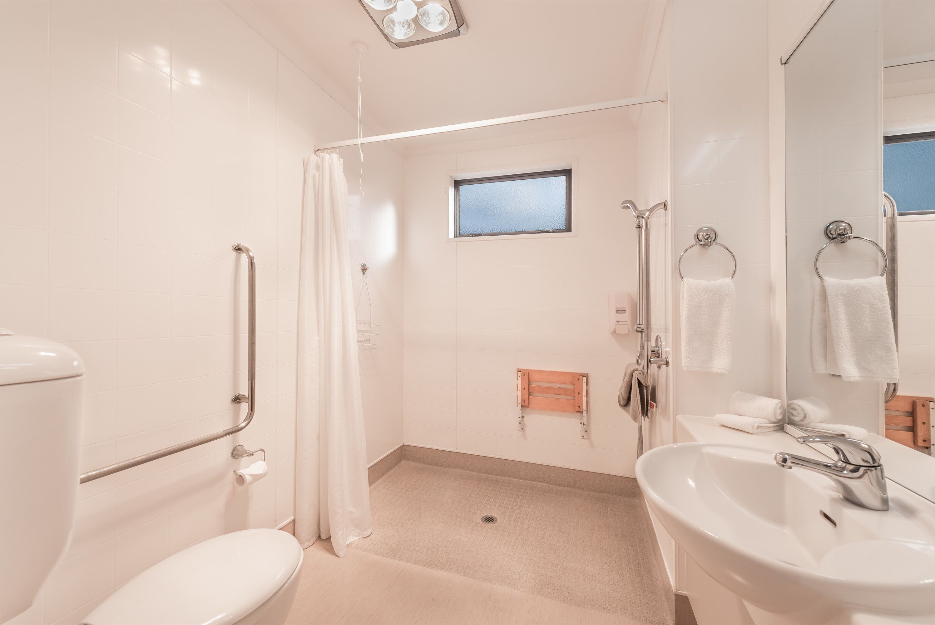 Une salle de bain avec des toilettes, une douche et un lavabo.