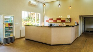 Un espace d’accueil comprenant un comptoir, un distributeur de boissons et une fenêtre donnant sur un espace verdoyant.