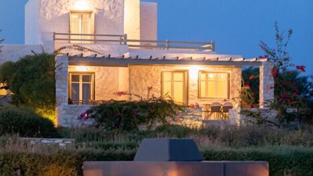 A modern villa with a pool, stone facade, and outdoor seating area. - Stagones Luxury Villas (Paros)