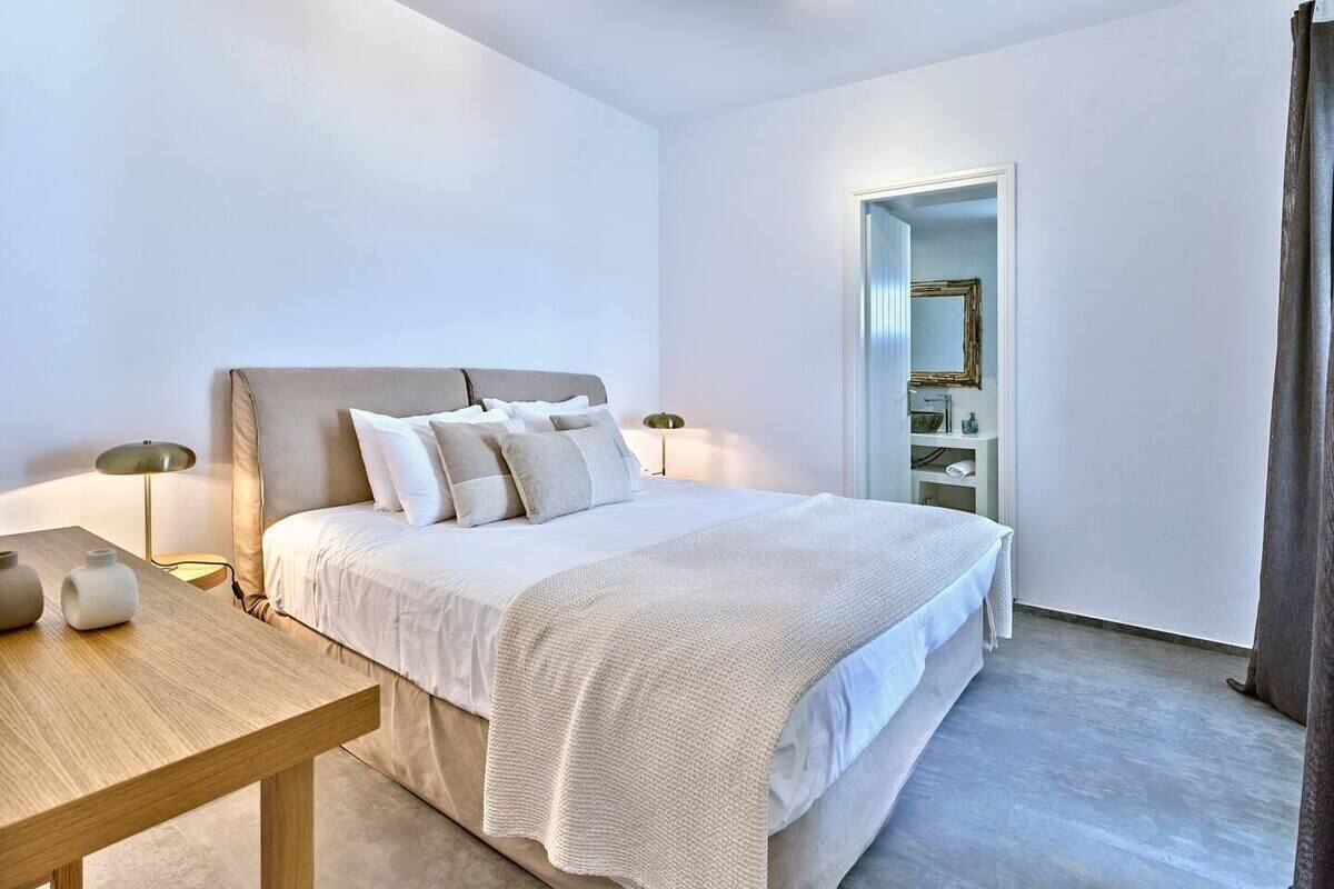 A modern bedroom with a large bed, bedside tables, and a nightstand.