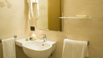 Ein Badezimmer mit Waschbecken, Spiegel, Handtuchhalter und Seifenspender.