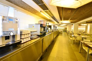 Eine gewerbliche Küche mit Edelstahlgeräten, darunter eine Cino-Espressomaschine, und einer Theke mit Gläsern.