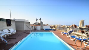 A swimming pool with lounge chairs and a view of the cityscape. - Hotel Sol & Sombra (Benidorm)