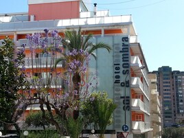 A hotel building with balconies and a sign indicating it is the "Hotel & Solmbrera."