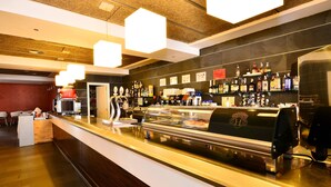 A bar area with a counter, various bottles, and a coffee machine. - Hotel Sol & Sombra (Benidorm)