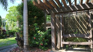 A wooden bench under a pergola with a wooden post nearby. - Riverview Resort & Conference Center (Calamba)
