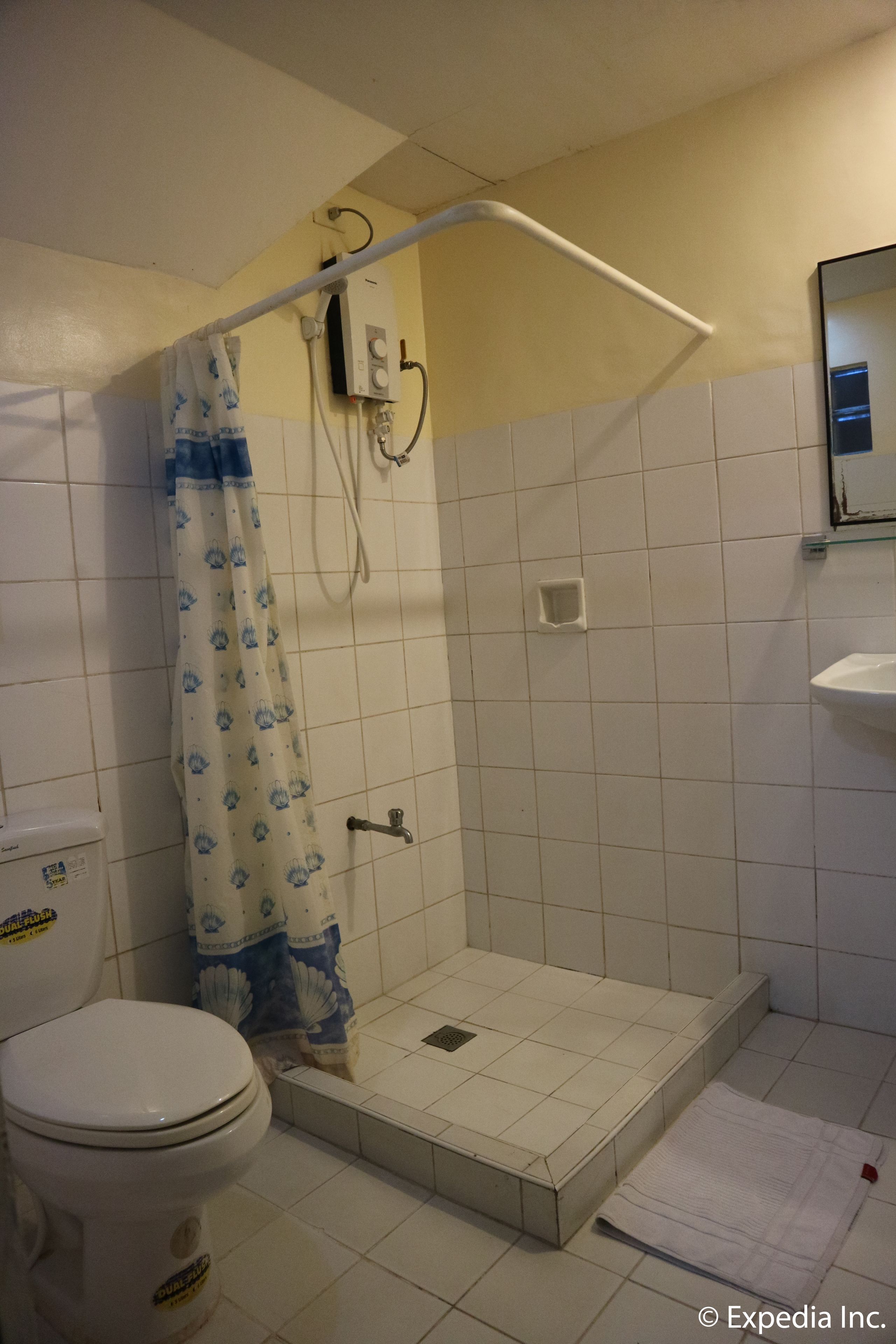 A bathroom with a shower, toilet, and sink.