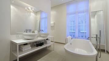 A modern bathroom with a large freestanding bathtub, a double sink vanity, and a large mirror above the vanity.