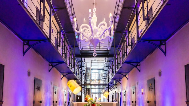 Un amplio vestíbulo de hotel con una zona de estar central, una araña y un diseño moderno.