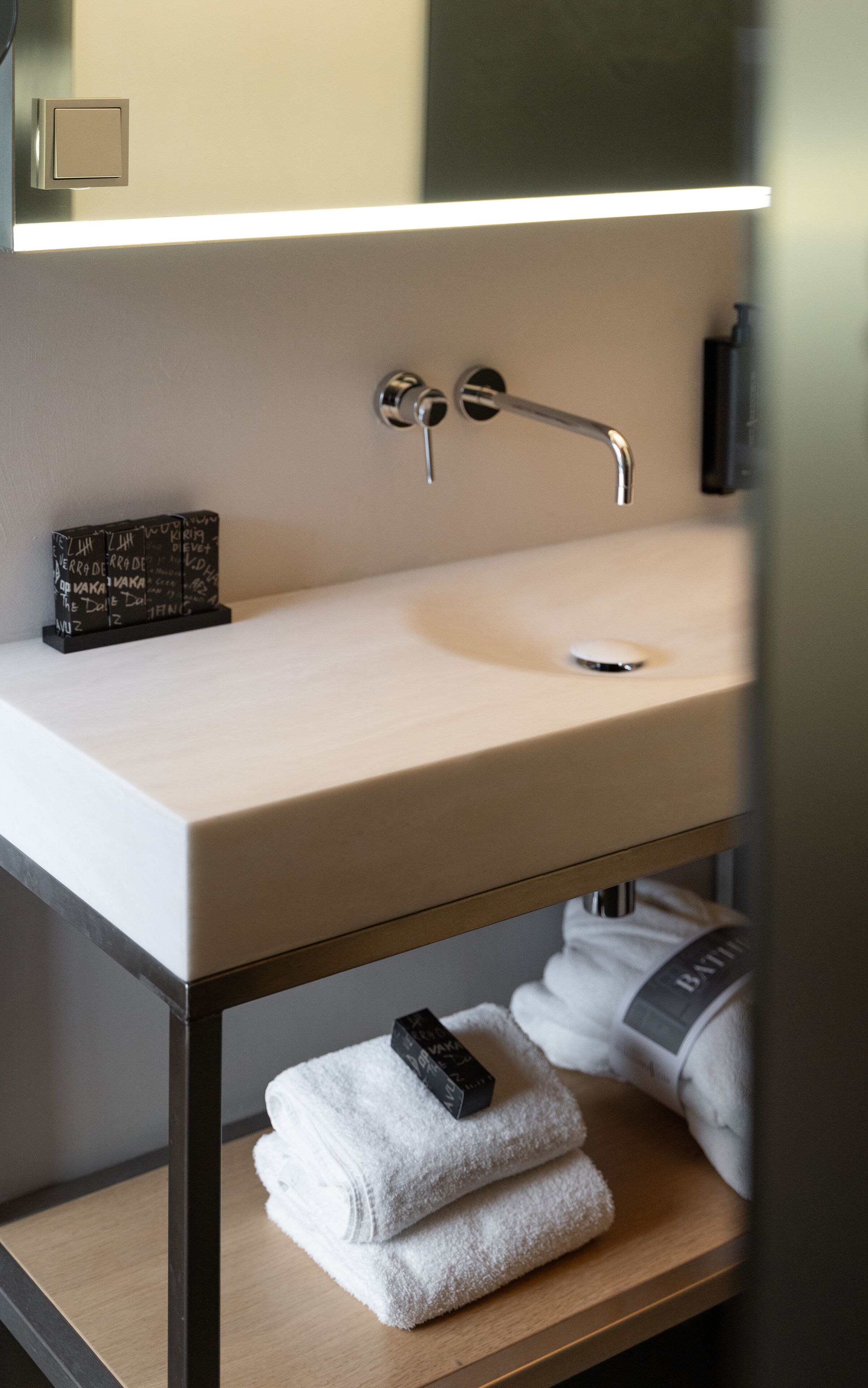 A bathroom with a sink, towel rack, and a mirror.