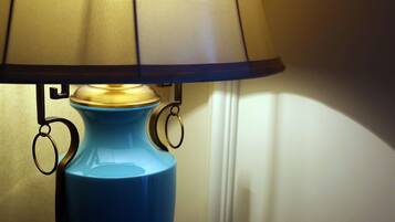 A blue table lamp with a gold base and a beige lampshade.