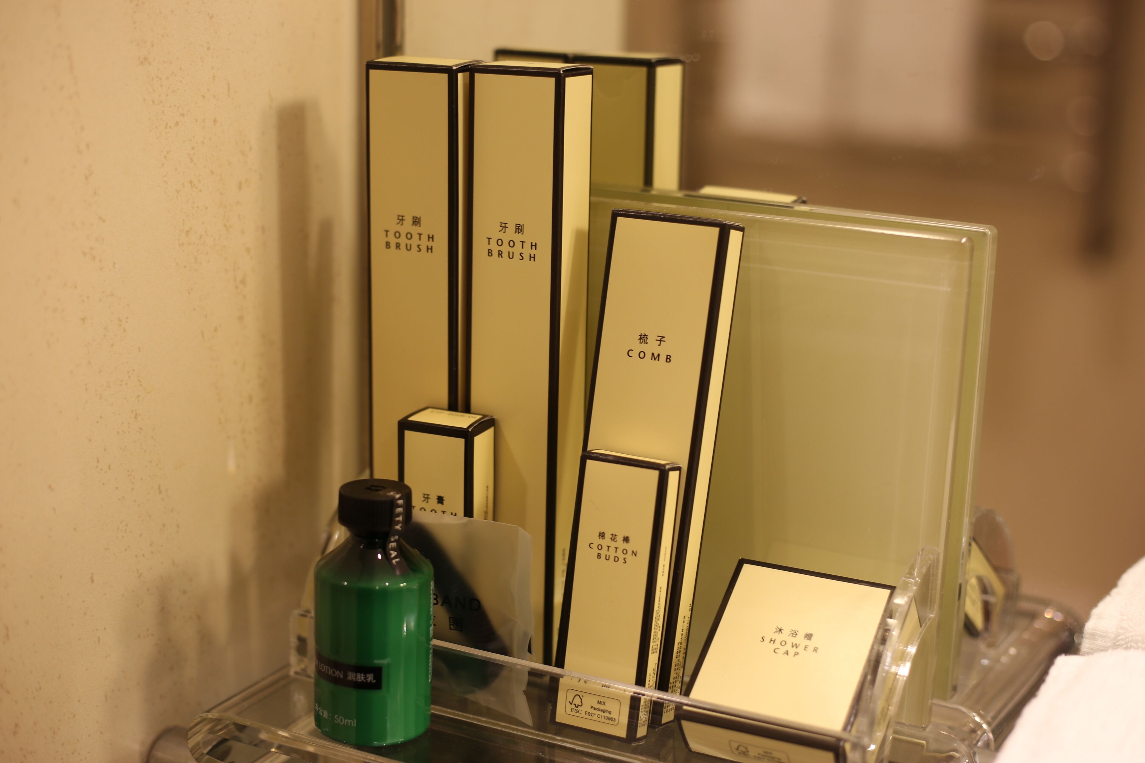 A display of toiletries including a green bottle, a comb, and several boxes labeled with Chinese characters.