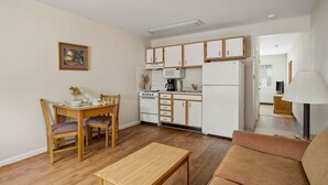 A compact living space with a dining area, kitchenette, and a sofa. - Affordable Suites Hickory/Conover (Conover)