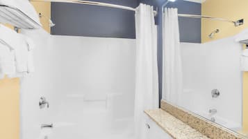 A modern bathroom with a shower, a toilet, and a vanity with a mirror.