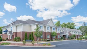 A Microtel Inn with a brick facade, multiple windows, and a parking lot.