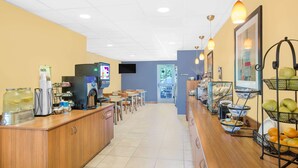 A cafe with a long counter, a coffee machine, and various food items displayed.