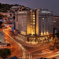 A multi-story hotel with a prominent "Hyatt Regency" sign, featuring a modern architectural design with a central atrium and multiple balconies.