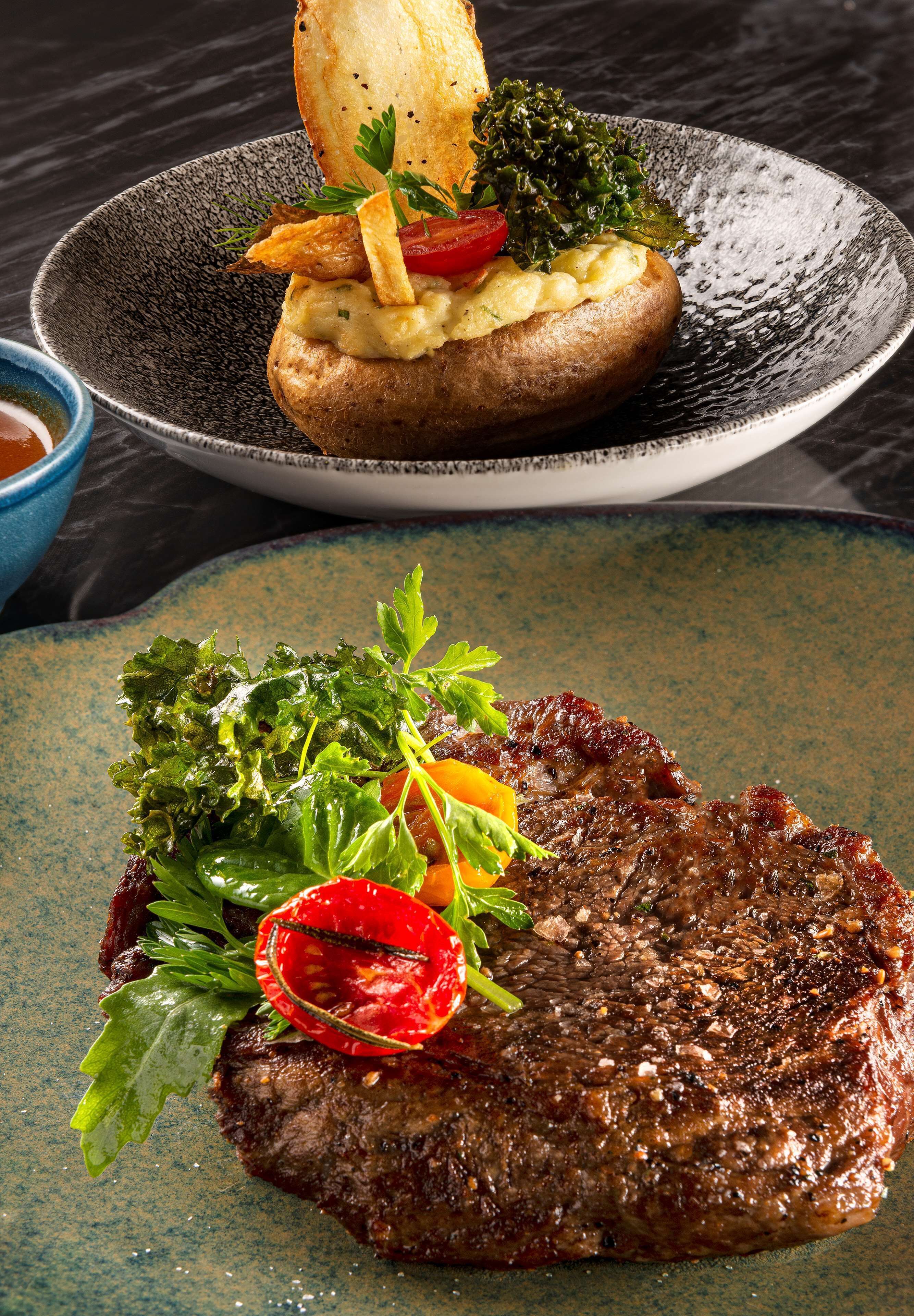Un plato de carne con vegetales y papas fritas.