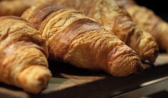 A close-up of several croissants on a wooden surface.