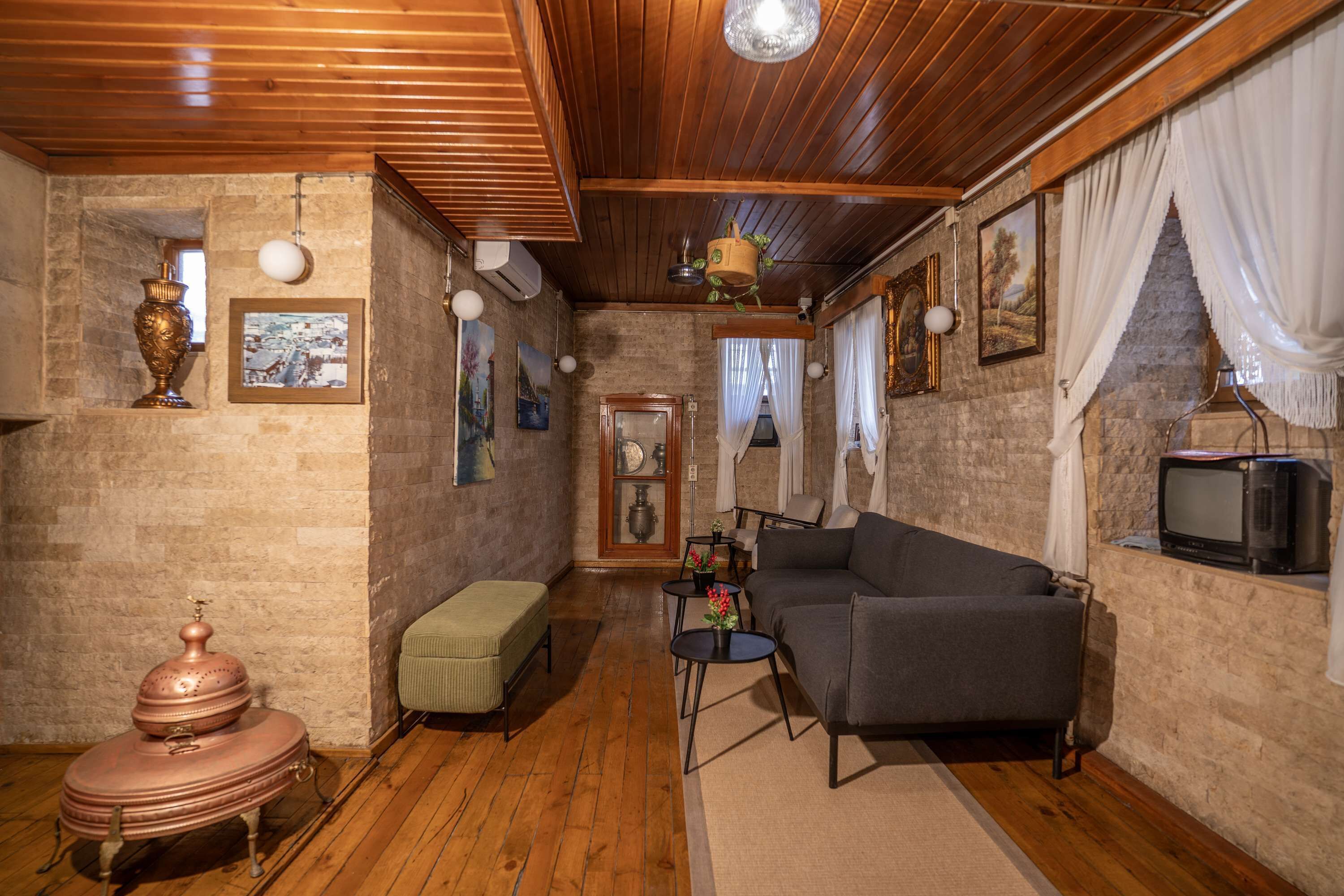Una sala de estar acogedora con un sofá, un reposapiés y un televisor.