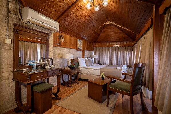 A wooden-finished room with a bed, a desk, a chair, and a mirror. - Zeynep Hanim Konagi - Special Class (Gaziantep)