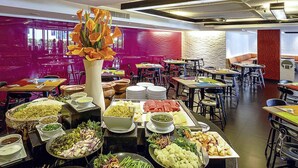A buffet setup with various dishes and a central floral arrangement. - ibis Styles Chiang Mai (Chiang Mai)