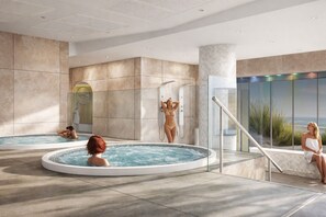 Un área interior de piscina moderna con múltiples jacuzzis, un área de ducha con paredes de vidrio y vistas al paisaje.