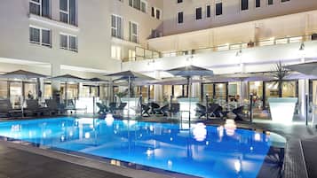 Een buitenzwembad en ligstoelen