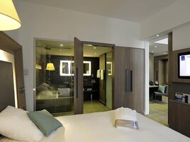 Una habitación de hotel con cama, escritorio, silla y televisión.