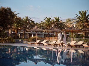 Una piscina al aire libre de temporada, sombrillas