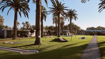 A well-maintained outdoor area with palm trees, a paved walkway, and a reception building labeled "CIVITEL".