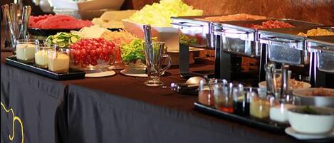 A buffet table with various food items and utensils.