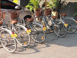 A row of bicycles parked in a designated area with yellow tags, likely for rental or use.