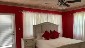 A bedroom with a bed, nightstand, and a ceiling fan. - Sapphire Garden Townhouses (George Town)