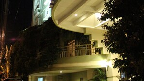 Un hôtel avec une entrée en forme d’arc, un balcon à l’étage supérieur et une enseigne indiquant qu’il s’agit d’un hôtel.