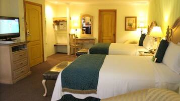 A hotel room with two beds, a desk, a chair, a television, and lamps.