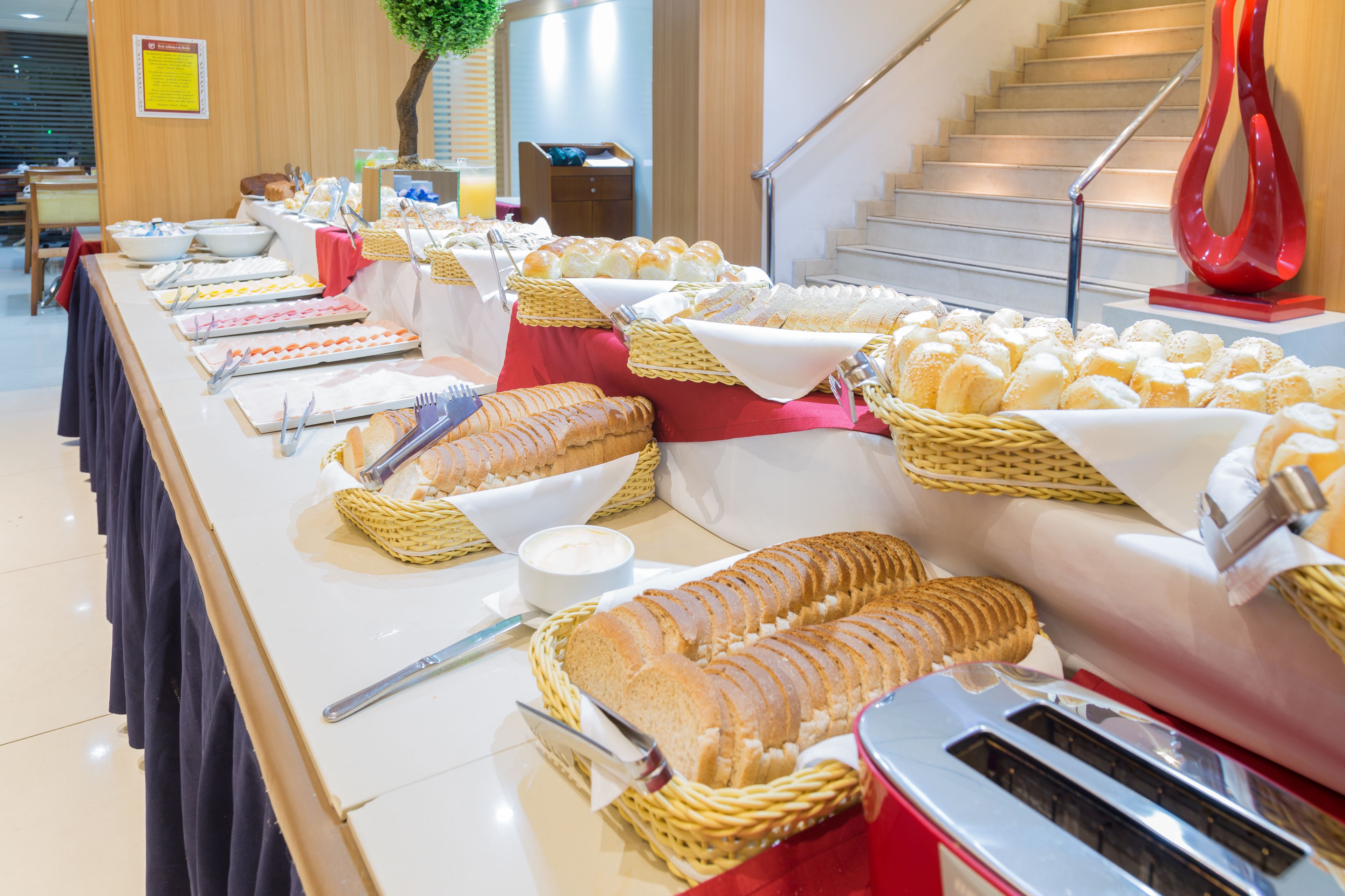 Buffet com diversos alimentos e utensílios.