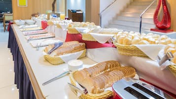 Buffet com diversos alimentos e utensílios.