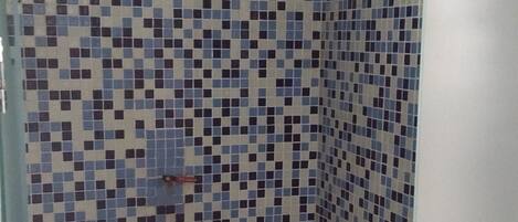 A small, tiled bathroom with a shower area.
