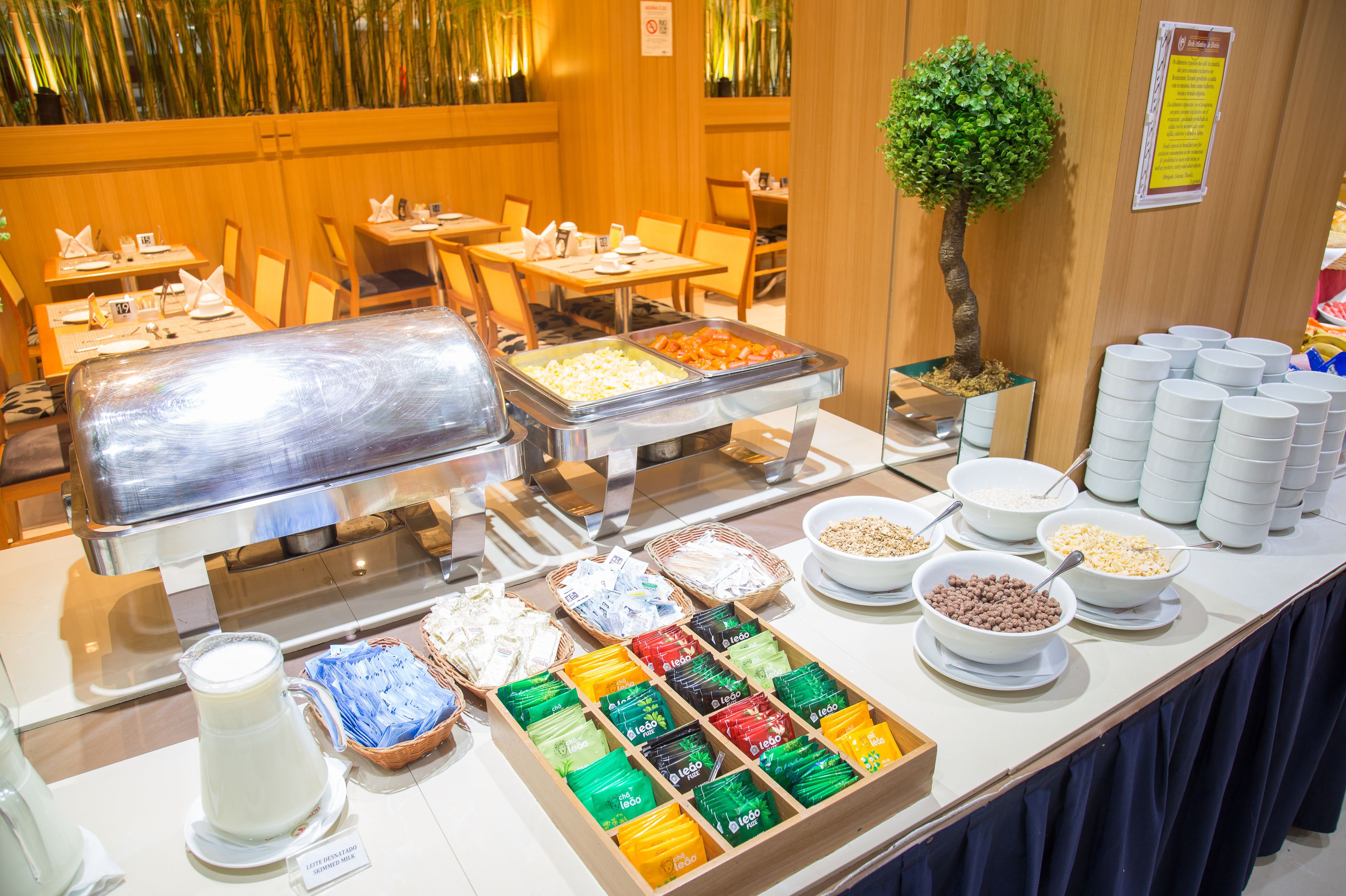 A buffet area with various food items, a milk jug, and a small tree.