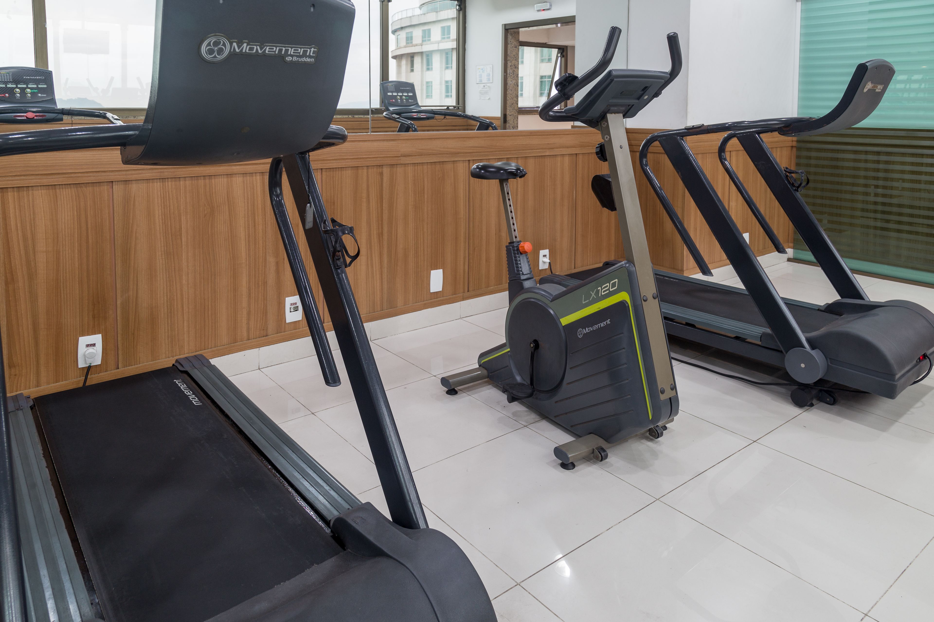 A gym with treadmills, an elliptical, and a stationary bike.