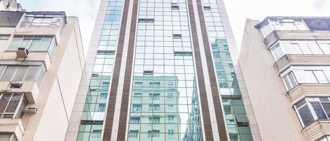 En modern hotellbyggnad med en glasfasad och det tydligt synliga namnet ”HOTEL ATLANTICO BUSINESS”.