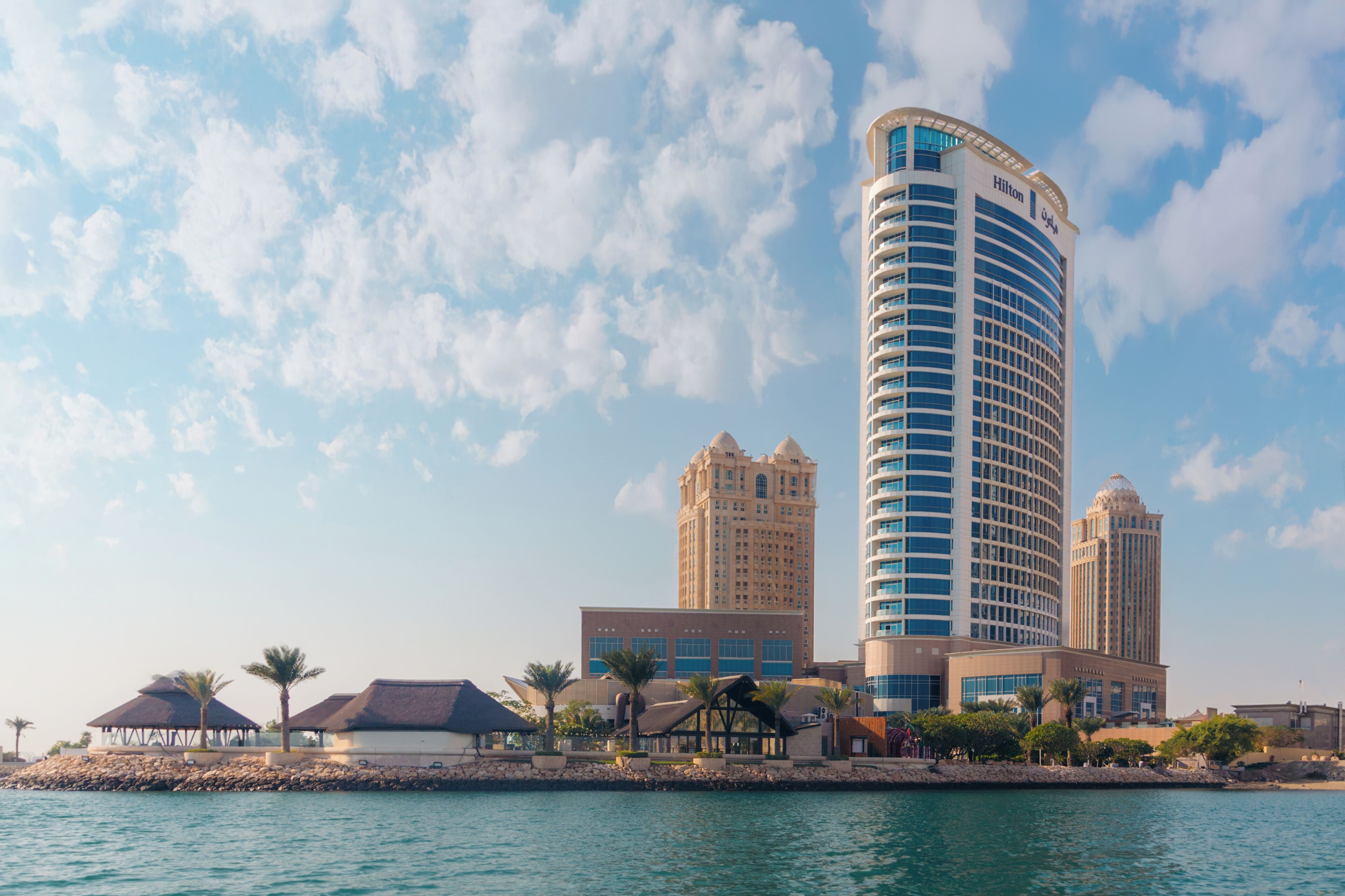 A hotel with a curved facade, multiple stories, and a prominent dome on top.