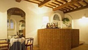 A room with a wooden bar area, a cushioned bench, and a tiled floor. - Country House La Locanda del Borgo (Pietralunga)