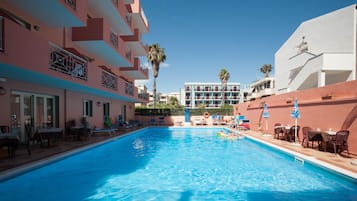 Una piscina al aire libre de temporada, tumbonas