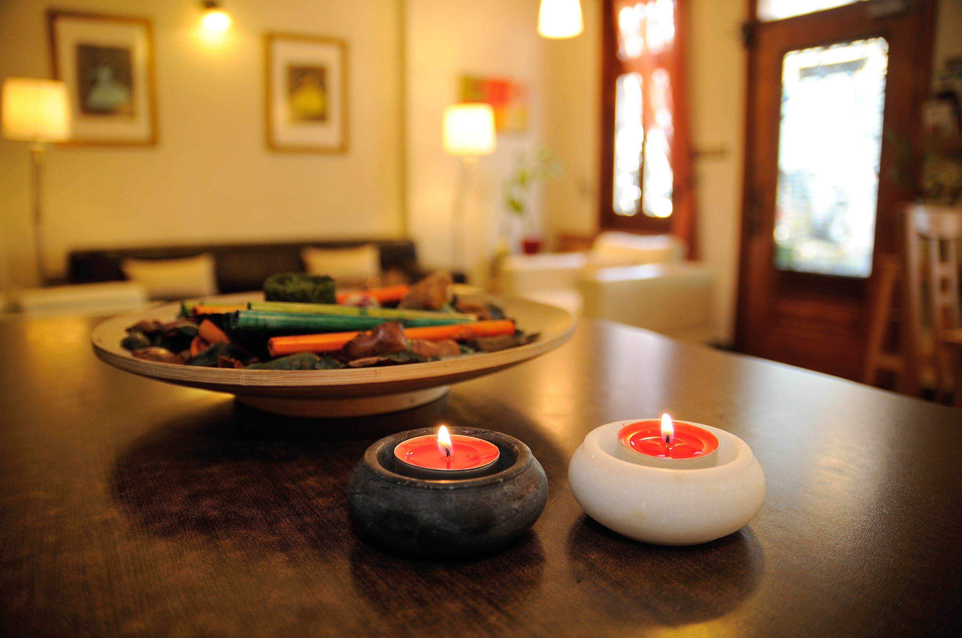 A dining table with a plate of food and two candles.