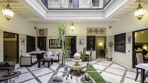 A spacious lobby with a central fountain, seating areas, and a balcony with decorative railings. - Riad Nesma Suites & SPA (Marrakech)