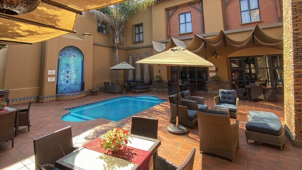 Alberca al aire libre y camastros 