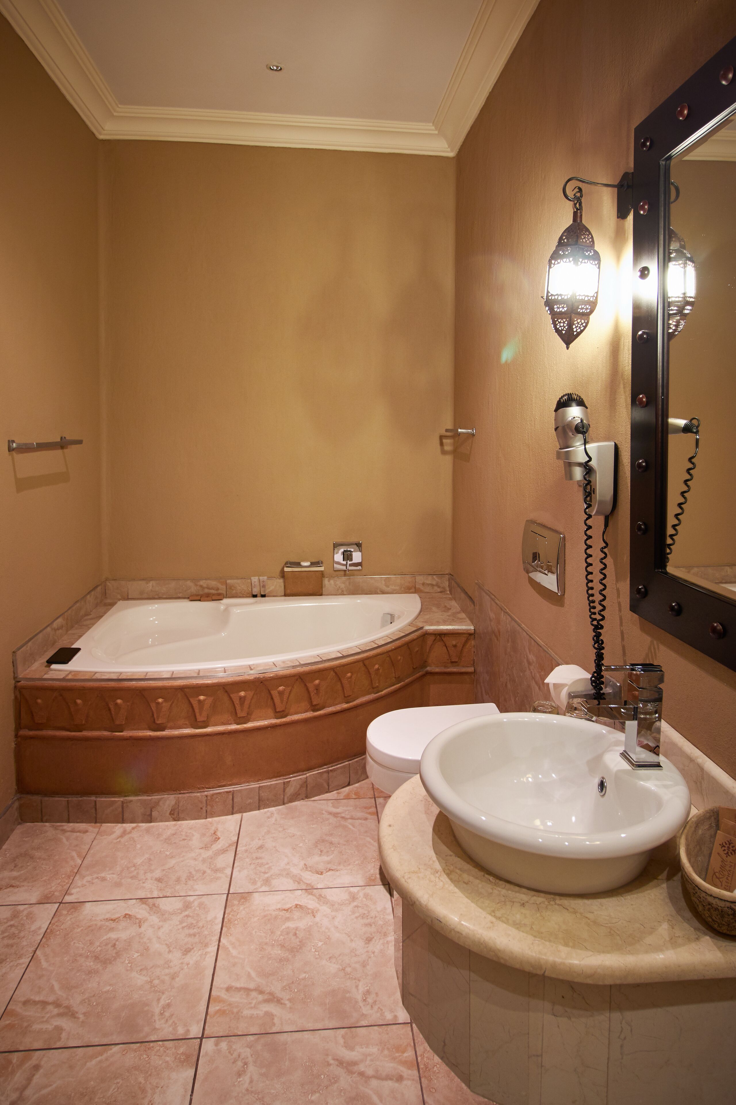 Un baño con una bañera independiente grande, un lavabo y un tocador con espejo.